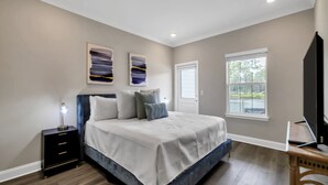 A bedroom with a bed, bedside table, and a window. - BRAND NEW Santa Rosa Beach/30A 4 Bedroom 3 Bathroom (Santa Rosa Beach)
