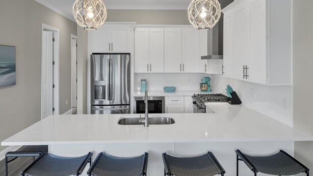 A modern kitchen with white cabinetry, stainless steel appliances, and a central island with bar seating. - BRAND NEW Santa Rosa Beach/30A 4 Bedroom 3 Bathroom (Santa Rosa Beach)