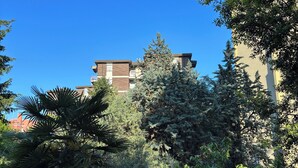 A building with a modern design, surrounded by dense greenery and trees. - CiaoMi - Hostel & Long Stay - Milano Niguarda & Bicocca  (Milan)