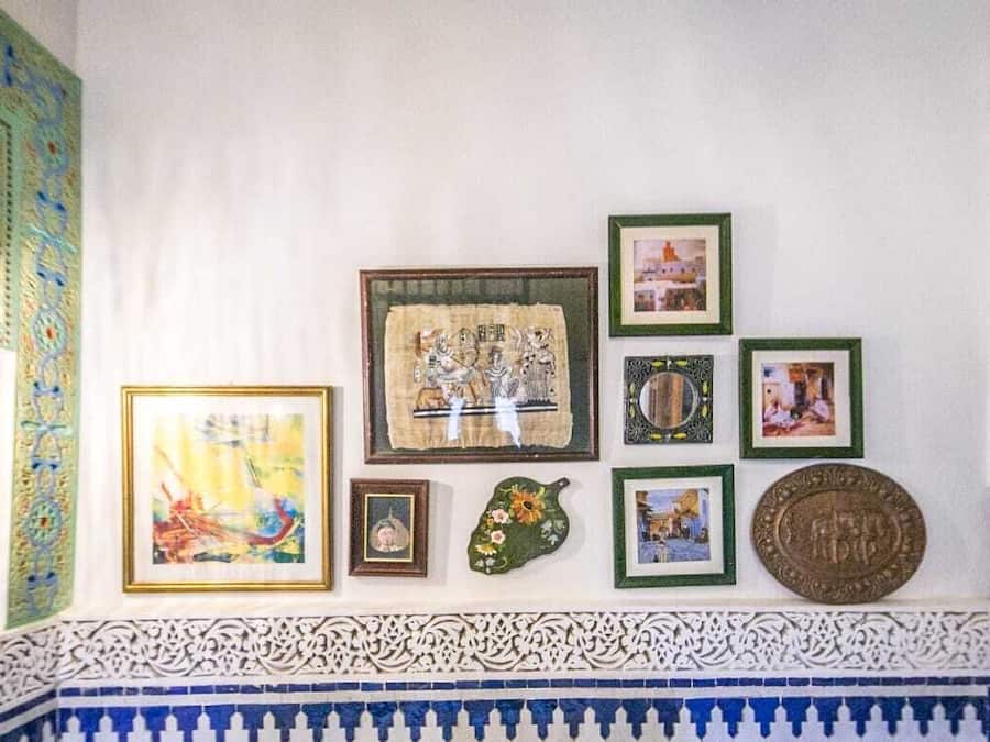 Paret amb diverses obres d'art enquadrades i una fusta decorativa de rajoles.