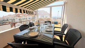 Área de refeições com uma mesa posta para seis pessoas, com vista para o horizonte urbano.