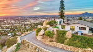 A modern house with a view of a cityscape and a mountain in the background.