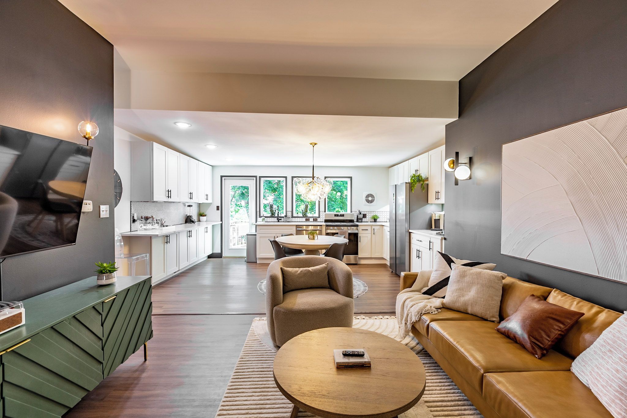 A modern living room with a sofa, a coffee table, and a TV mounted on the wall.