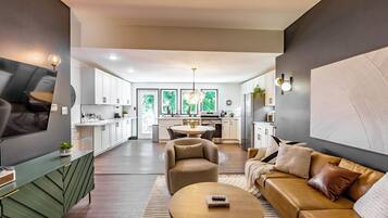 A modern living room with a sofa, a coffee table, and a TV mounted on the wall.