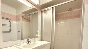 A bathroom with a white sink, mirror, and a glass shower enclosure. - HOTELL CITY KARLSHAMN (Karlshamn)
