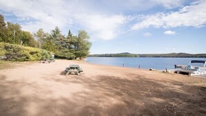 A lakeside campsite with picnic tables and a boat dock.