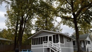 Ein eingeschossiges Haus mit Veranda und einer Treppe, die zum Eingang führt.