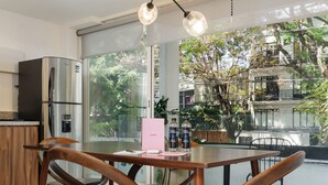 A modern kitchen with a large island, stainless steel appliances, and a view of the outdoors. - Wynwood House Allan Poe (Mexico City)