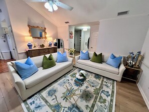 A living room with two sofas, a coffee table, and a patterned rug. - Coastal White Cottage-Isle Of Hope in Savannah (Savannah)