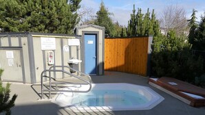 A small outdoor pool area with a wooden deck, a metal ladder, and a small shed with a blue door. - Ocean View Townhome - Sooke Harbour Marina (Sooke)