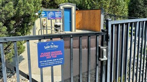 Senyal d'una banyera d'hidromassatge en un complex turístic, amb l'horari d'operació i números de contacte d'emergència.
