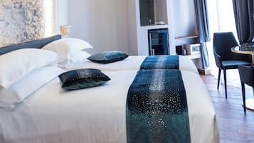 A hotel room with a large bed, a wardrobe, a desk, and a chandelier.