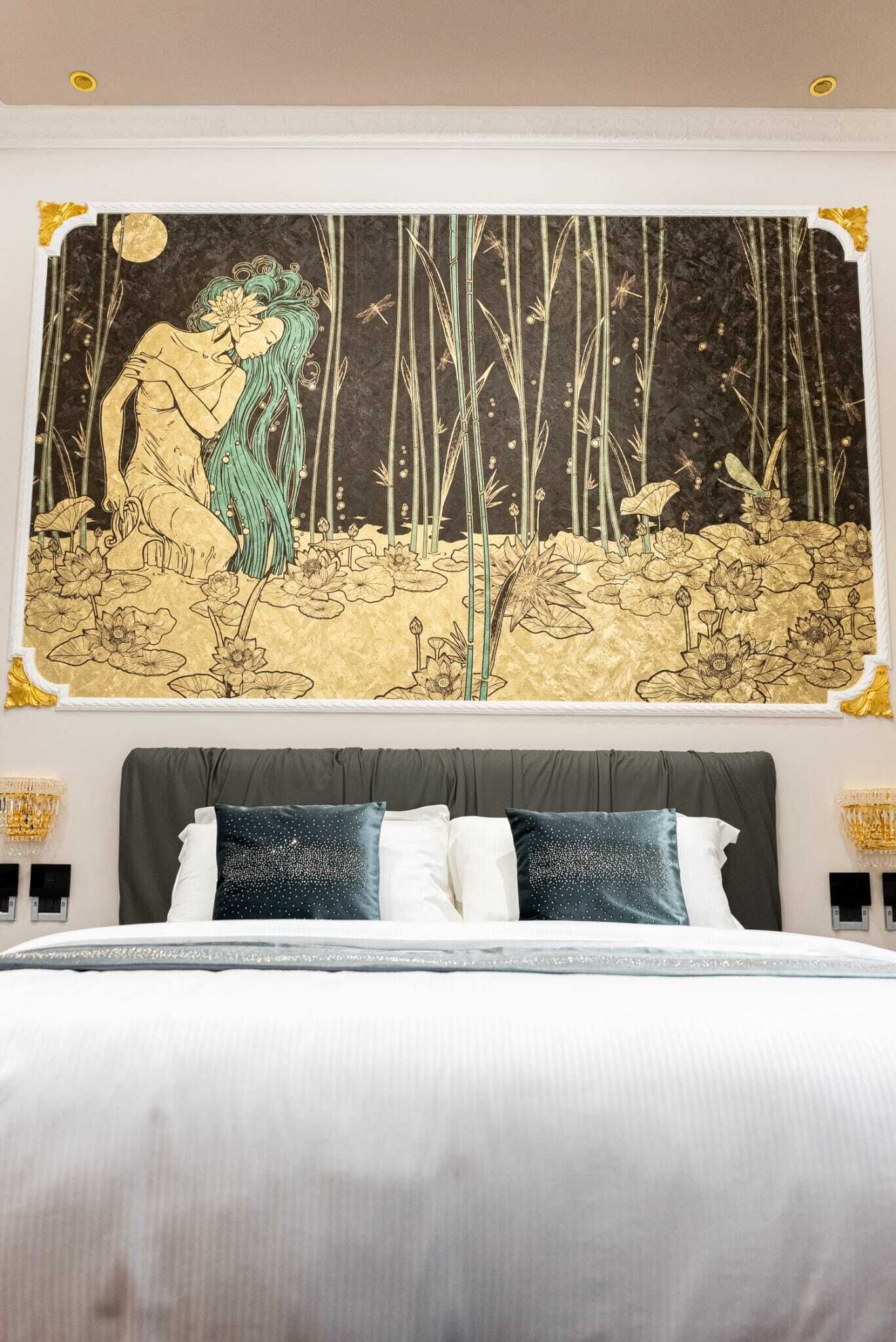 Ein Schlafzimmer mit einem großen Bett, einem Kopfteil und einer Wandmalerei, die eine Waldszene zeigt.