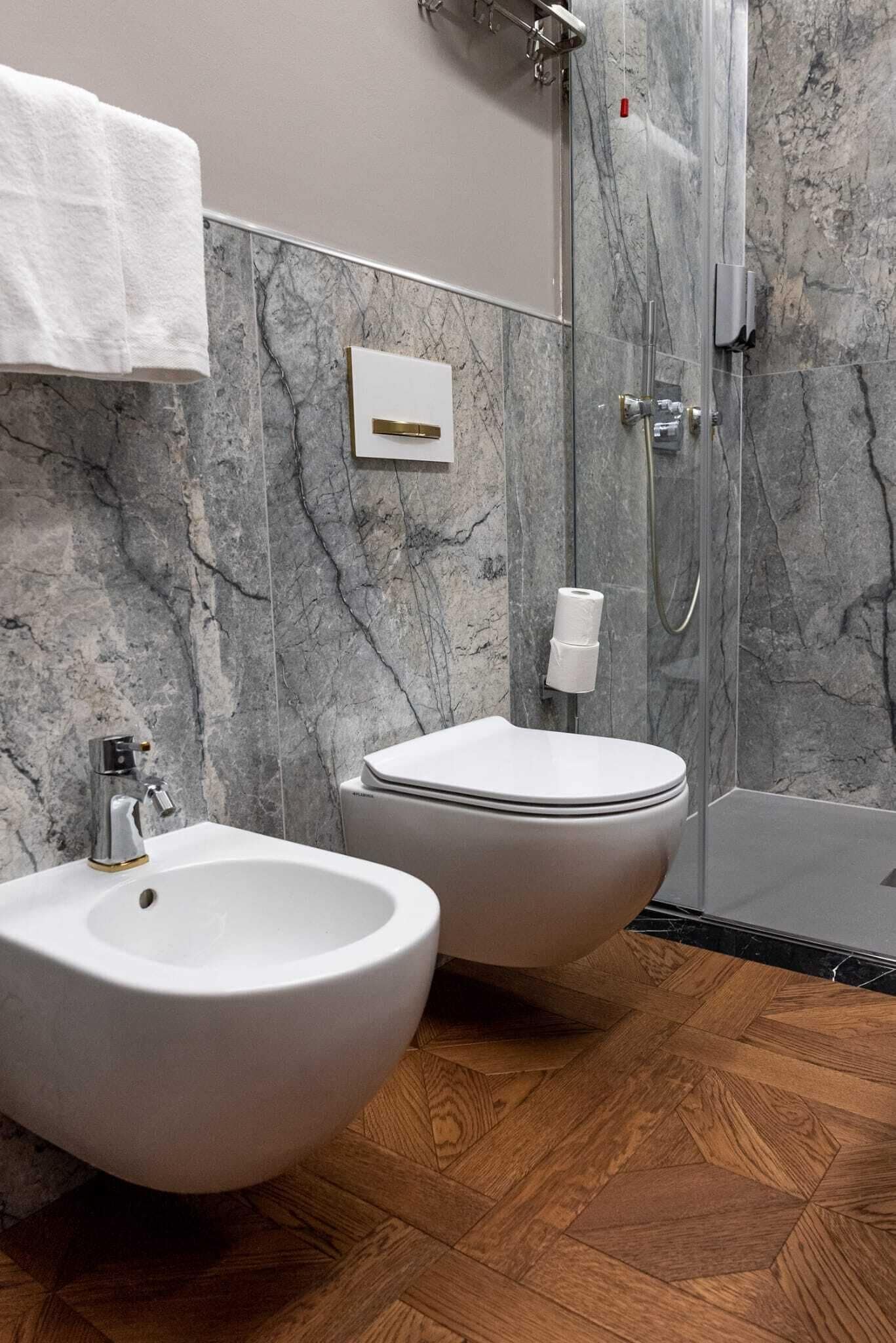 Une salle de bain équipée d’un bidet, de toilettes et d’une douche.