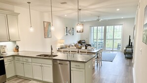 A spacious kitchen with a large island, stainless steel appliances, and pendant lighting.
