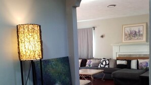 A living room with a modern lamp, a painting, a sofa, and a fireplace. - Fairmount House at The Mann (Philadelphia)