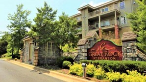 A multi-story building with a stone facade and a sign reading "Great Rock at Branson". - Downtown 1BR Condo in Great Rock Resort (Branson)