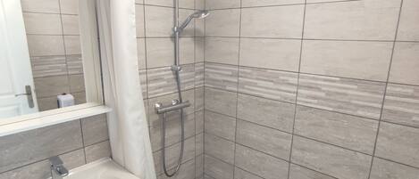 A modern bathroom with a shower, toilet, and sink.