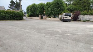 Un estacionamiento con una camioneta blanca estacionada a lo lejos.