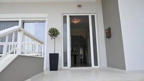 Un interior moderno con una escalera, una planta en maceta y un acceso a un comedor.