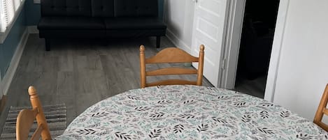 A room with a round table, a bench, and a door.