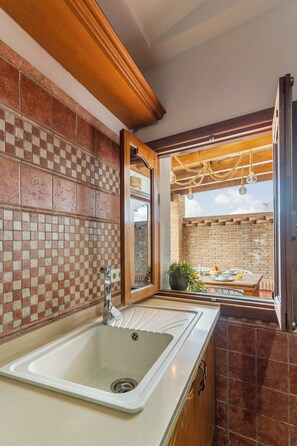 Una cocina con un lavamanos, una ventana y vistas al exterior.
