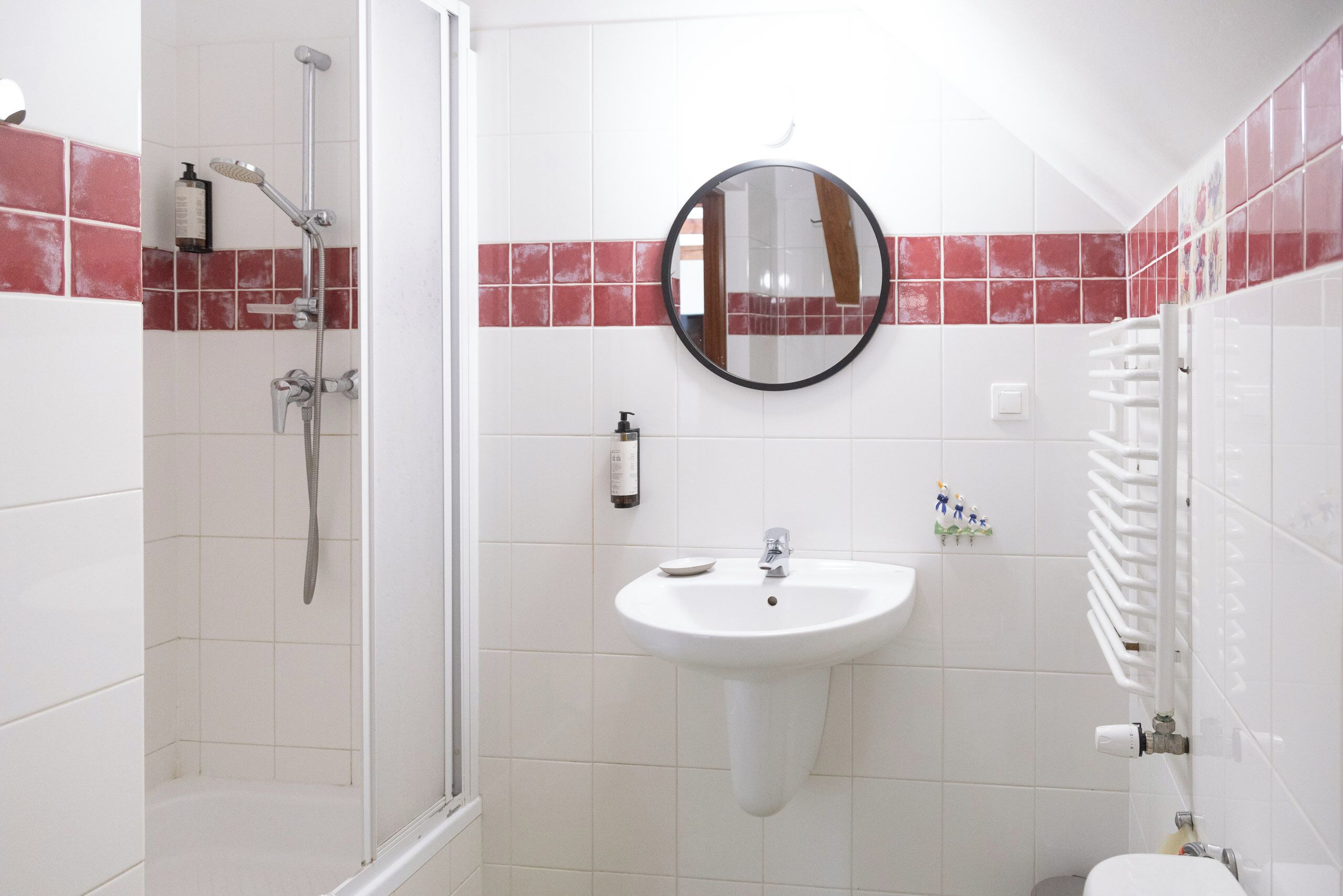 A bathroom with a shower, sink, and toilet.