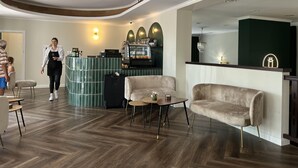 A modern interior with a bar area, plush seating, and a wooden floor. - Mleczarnia Hotel Restauracja (Suchy Las)