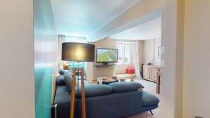 A living room with a sofa, a TV, a lamp, and a window. - Zum Storike Nescht (Barr)