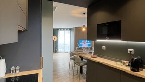 Una cocina moderna con encimera de madera, horno integrado y televisor de pantalla plana montado en la pared.