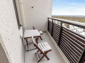 A balcony with a white railing, a table, and two chairs covered in snow. - Nordic chalet 9402 by Interhome (Ylläsjärvi)