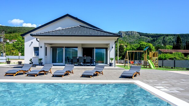 A modern building with a swimming pool, sun loungers, and a children's play area. - Rest for the soul by Interhome (Imotski)