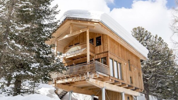 A wooden cabin with a balcony, surrounded by snow-covered trees. - #9 mit IR-Sauna & Sprudelwanne Innen by Interhome (Turracher Höhe)
