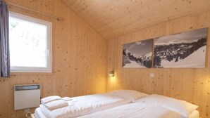 A wooden-paneled room with two beds, a window, and two wall-mounted pictures. - #9 mit IR-Sauna & Sprudelwanne Innen by Interhome (Turracher Höhe)