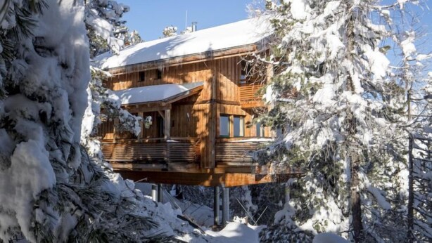 A wooden cabin with a balcony, surrounded by snow-covered trees. - #4 mit IR-Sauna & Sprudelwanne innen by Interhome (Turracher Höhe)
