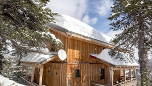 A wooden cabin with a covered porch and a snow-covered roof, surrounded by trees. - #4 mit IR-Sauna & Sprudelwanne innen by Interhome (Turracher Höhe)