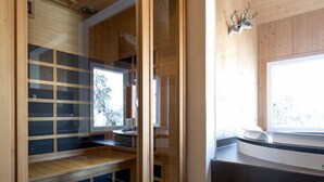 A sauna room with wooden walls, a glass door, and a bench. - #4 mit IR-Sauna & Sprudelwanne innen by Interhome (Turracher Höhe)