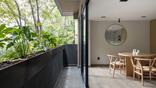 A modern room with a balcony, a round table with chairs, and a large mirror on the wall. - Wynwood House Sinaloa (Mexico City)