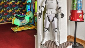 A toy Stormtrooper figure next to a Pringles can dispenser.