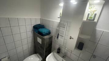 Ein kleines Badezimmer mit Toilette, Waschbecken und Handtuchhalter.