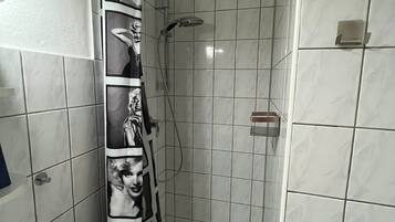 A bathroom with a shower, tiled walls, and a toilet.