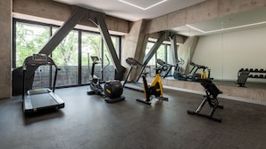 A modern gym with treadmills, stationary bikes, and a rowing machine. - Wynwood House Londres (Mexico City)