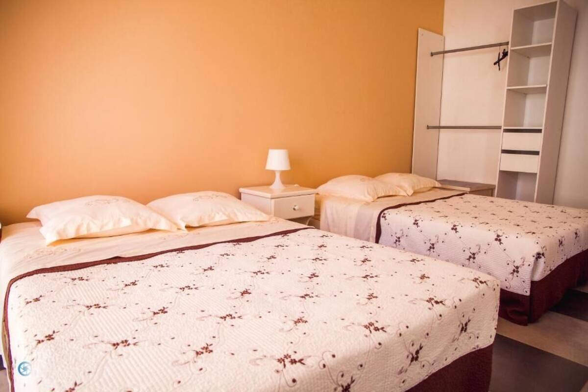 Ein Schlafzimmer mit zwei Betten, einem Nachttisch, einer Lampe und einem Kleiderschrank.