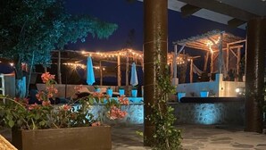 Un patio al aire libre con suelo de piedra, plantas en macetas y mobiliario exterior.