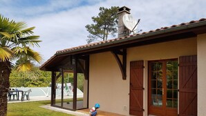 A house with a covered patio, a chimney, and a garage door. - FAMILY HOUSE FOR 6 PEOPLE (Lit-et-Mixe)