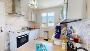 A compact kitchen with a gas stove, oven, and a coffee machine. - Dolce Vita close to the beach - Terrace & Garden (Saint-Hilaire-de-Riez)