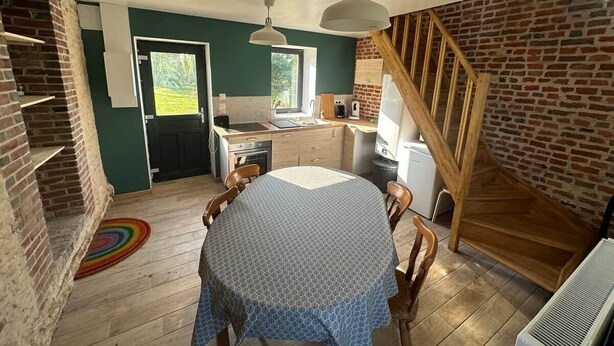 A dining area with a round table, chairs, and a ceiling fan. - Joli Gîte de Campagne au Milieu des Champs - 4 à 8 Personnes (Neauphe-sur-Dive)