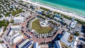 An aerial view of a coastal area with a central plaza, buildings, and a beach. - Beachside Dreams, at Boutique Beachside Villas, Newly Renovated and Decorated (Santa Rosa Beach)