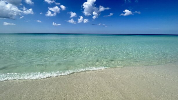 A beach with clear turquoise water and a sandy shore under a blue sky with scattered clouds. - Beachside Dreams, at Boutique Beachside Villas, Newly Renovated and Decorated (Santa Rosa Beach)