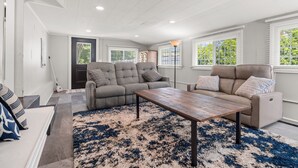 A living room with a sofa, a coffee table, and a rug. - A Winfield Bungalow (Dover)